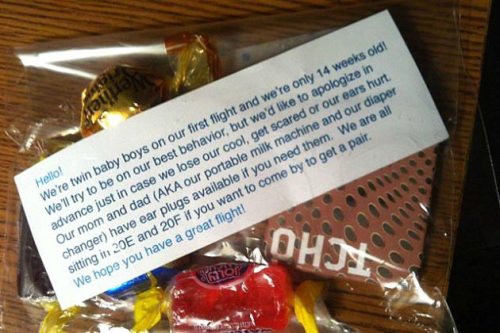 Couple flying with twin babies pass out candy to passengers