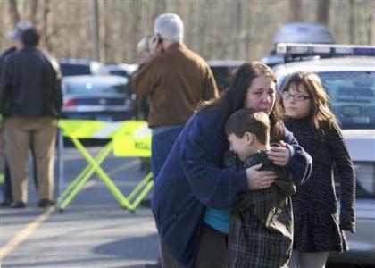 A young boy is comforted outside Sandy Hook Elementary School after a shooting in Newtown